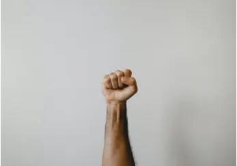 A raised fist symbolizing triumph and recognition, representing awards and accomplishments in a powerful gesture.